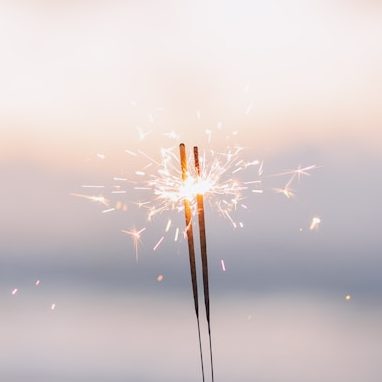 Funke einer Wunderkerze vor unscharfem Hintergrund, hell erleuchtet.